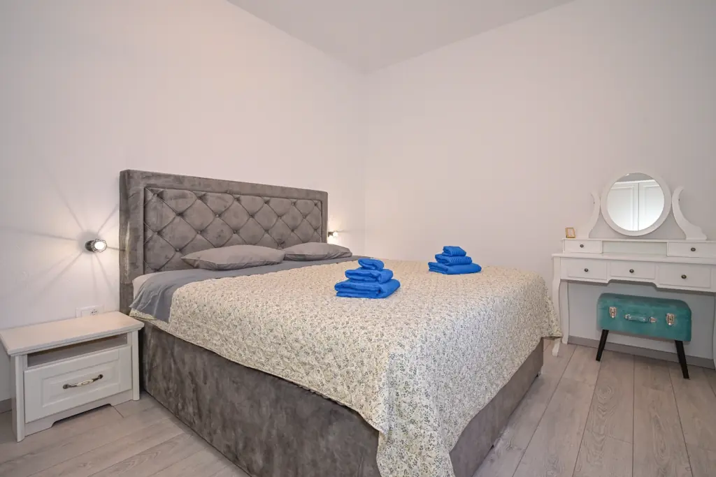 Spavaća soba s bračnim krevetom i toaletnim stolićem, apartman AMI Strožanac