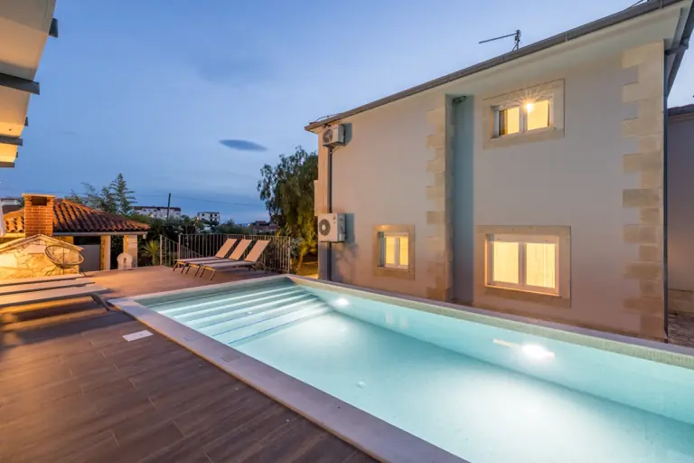 Villa Artea s osvijetljenim bazenom u sumrak, Podstrana